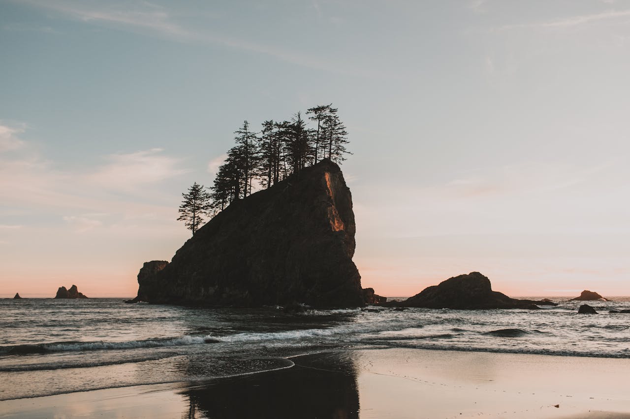 Dramatic sunset over a rock formation at a Pacific Northwest beach.